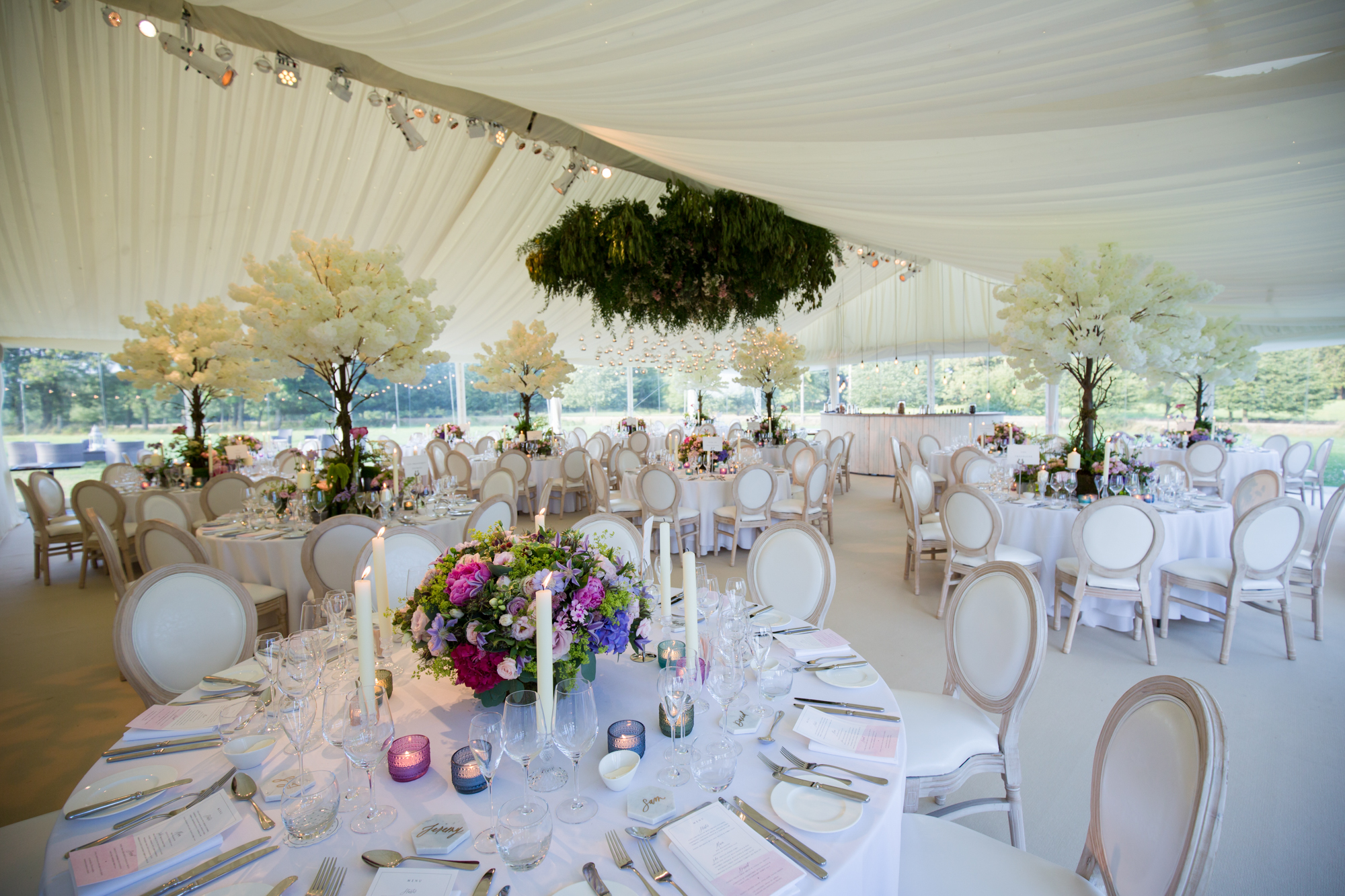 Wedding marquee with flower centrepieces and hanging florals 